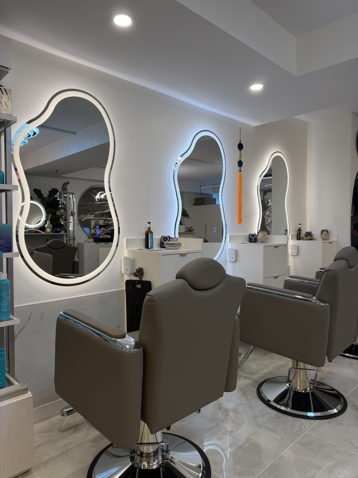 Fauteuils de coiffure face à des miroirs rétroéclairés